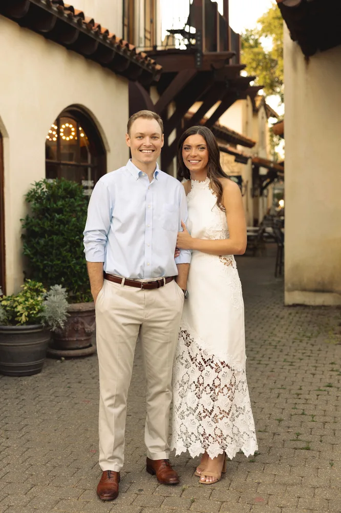 Alexandra and Dalton standing together by a courtyard staircase