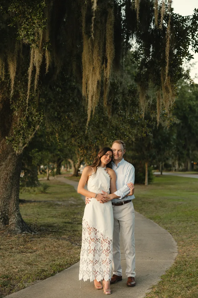 Alexandra and Dalton embracing beneath oak trees