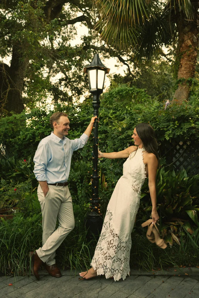 Alexandra and Dalton reaching toward each other beside a garden lamp