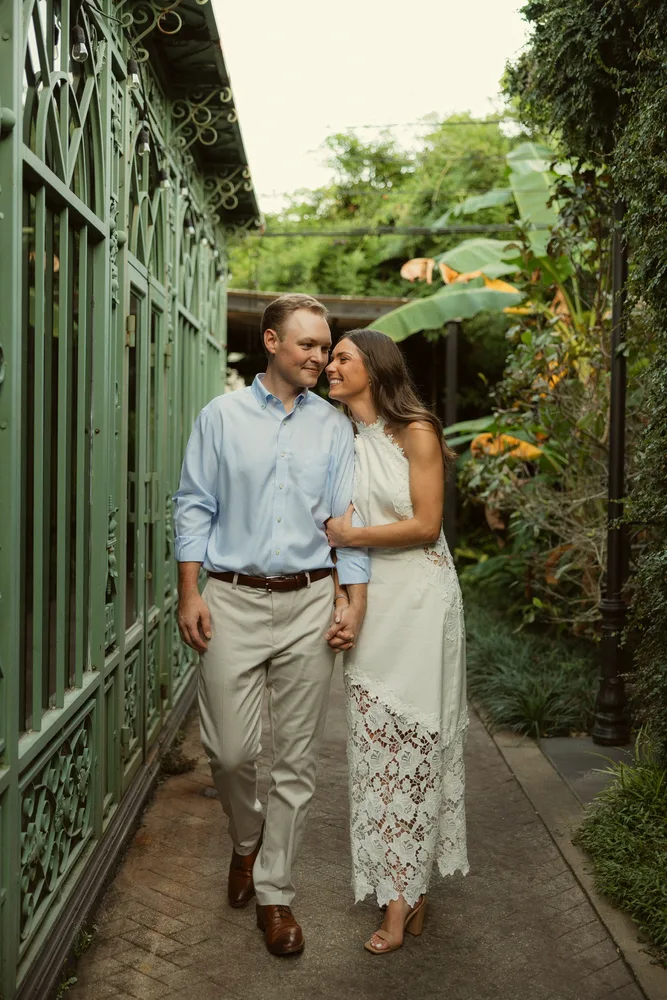Alexandra and Dalton walking together beside a green gate