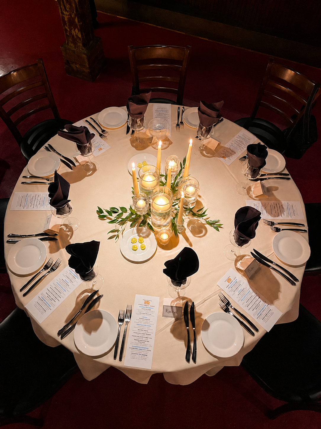 Candlelit round table setting at NOJA for the rehearsal dinner